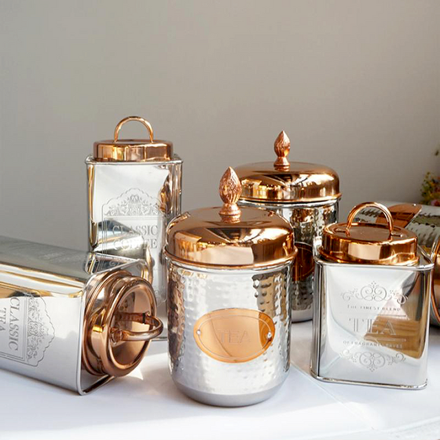 stainless steel sealed tea storage canister with a pineapple handle on the table