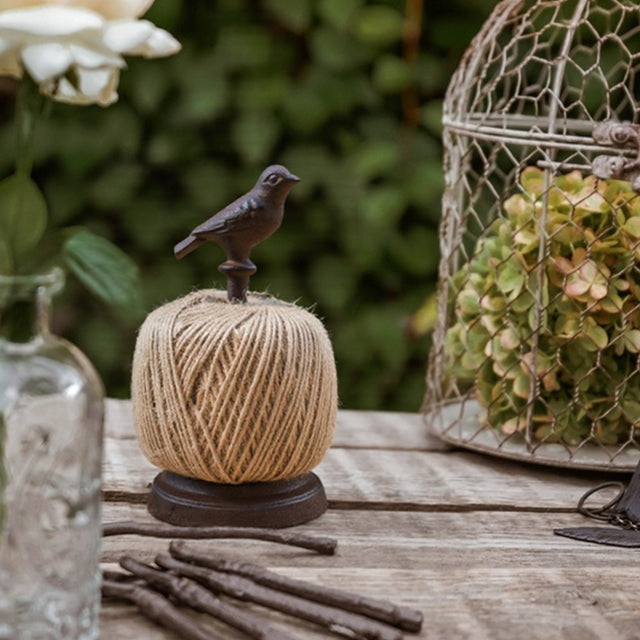standing bird thread spool on a wood table