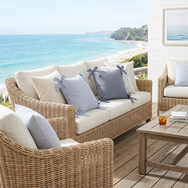 striped bow pillows on coastal patio wicker sofa