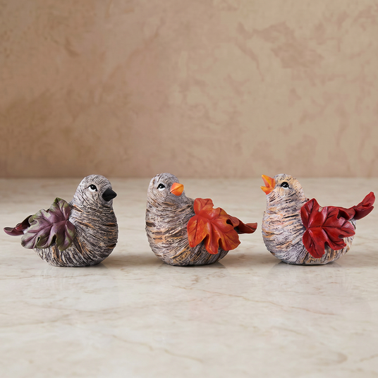three autumn leaf bird sculptures on marble