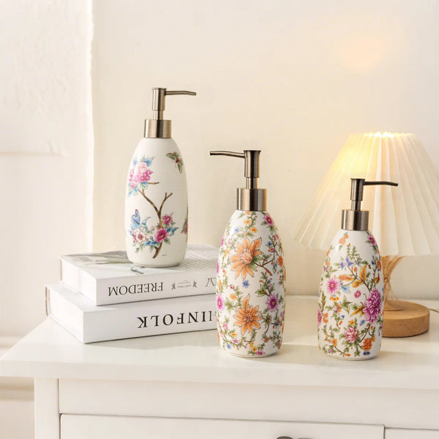 three floral ceramic soap dispensers on a table