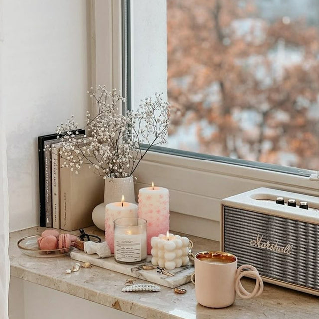 two pink mold-poured candles near the window