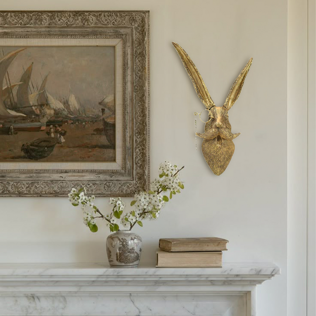 vintage bronze resin animal wall decor beside the hanging painting