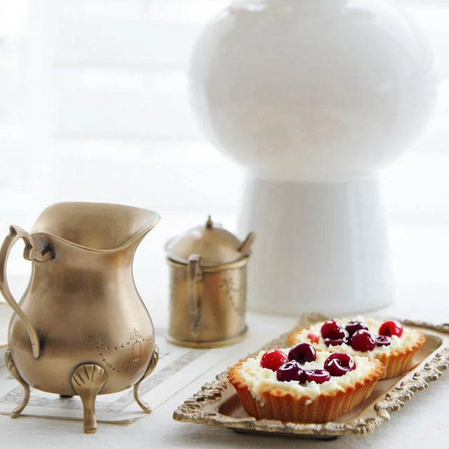 vintage carved brass floral design serving tray placing desserts on the table