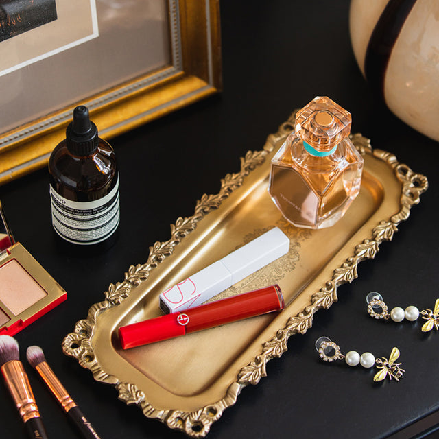 vintage carved brass floral design serving tray storing cosmetics on the table