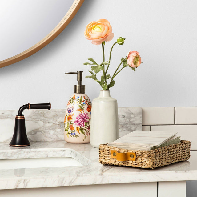 vintage floral ceramic soap dispenser near a sink