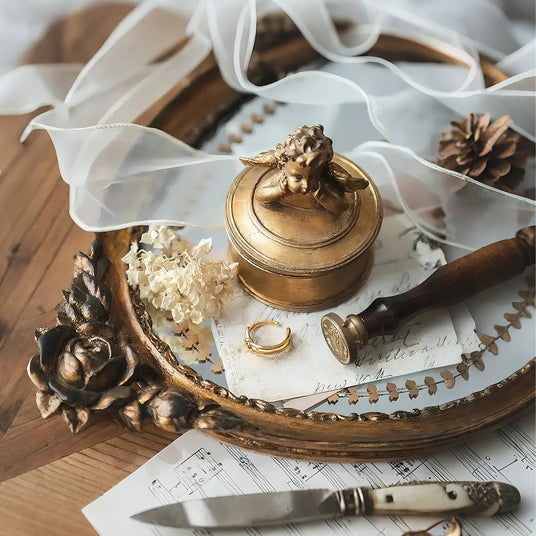 vintage gold round resin cherub trinket box on a tray