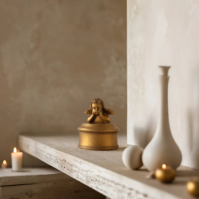 vintage gold round resin cherub trinket box on tabletop