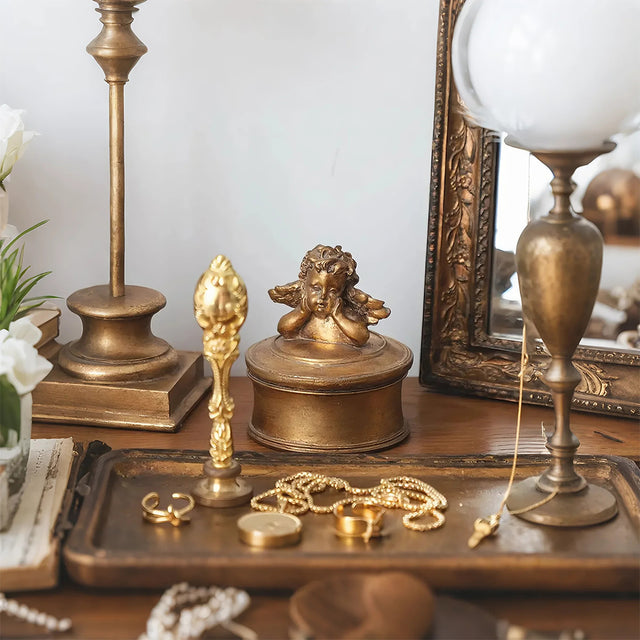 vintage gold round resin cherub trinket box on the dresser