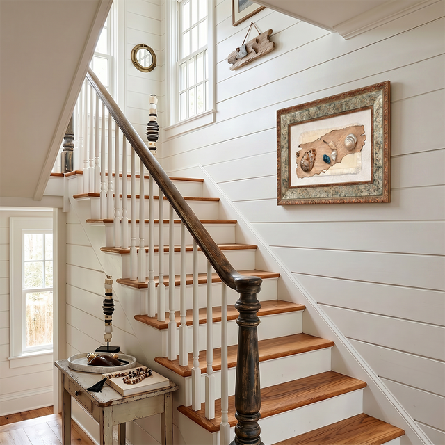 vintage shell art hanging on staircase wall
