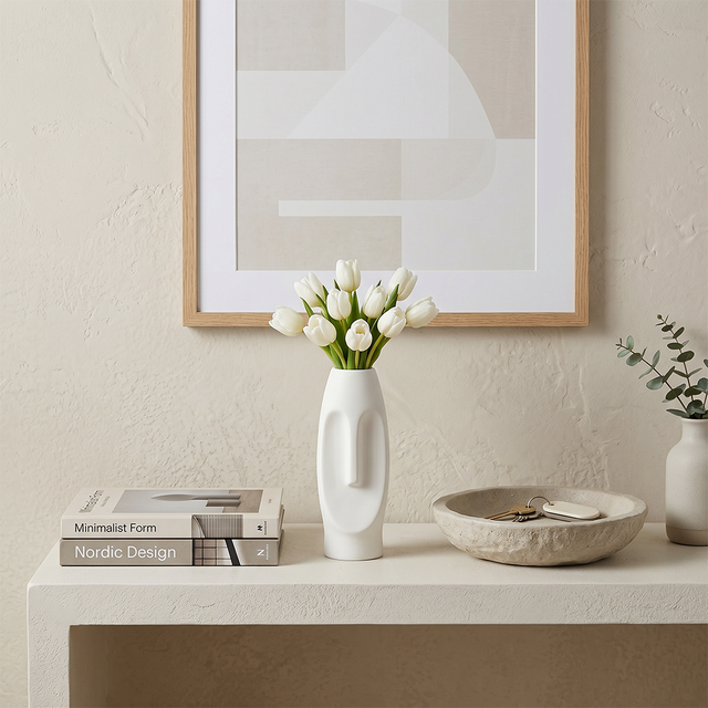 white face vase with tulips on white console