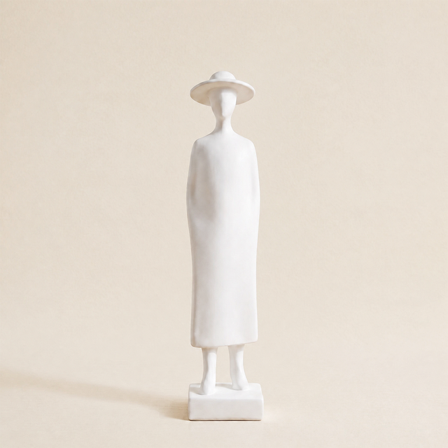 white figurine wearing dress and sun hat