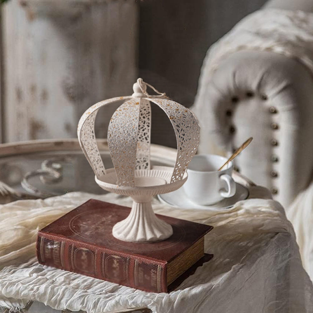 white metal crown hurricane candle holder on a book