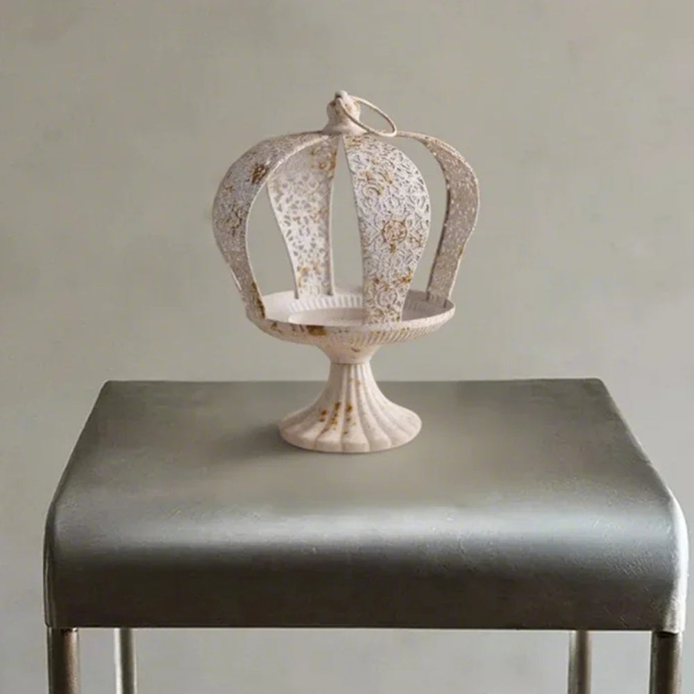 white metal crown hurricane candle holder on the table