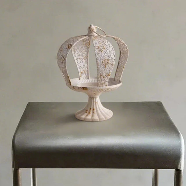 white metal crown hurricane candle holder on the table