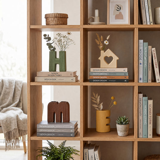 wooden bookshelf display with letter vases and plants