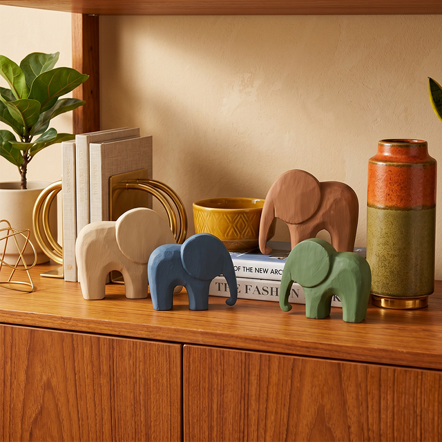 wooden elephants on wooden cabinet with books