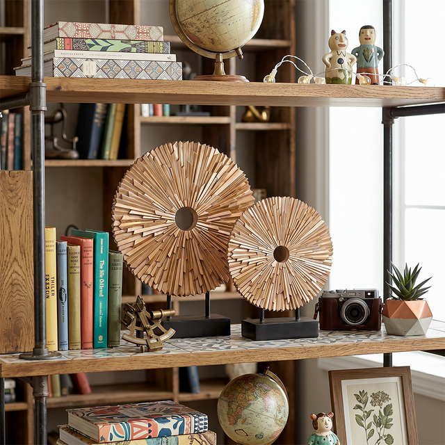wooden sunburst sculptures on shelf with books