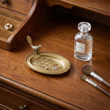 Bird ornament tray on warm wood dresser