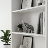 Carved elephant statue inside white open bookshelf
