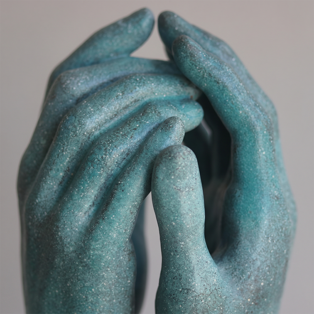 Closeup intertwined teal hand carving