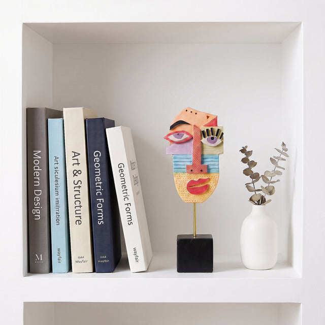 Colorful Face Sculpture On White Bookshelf