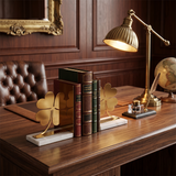 Golden bookends on vintage wood desk
