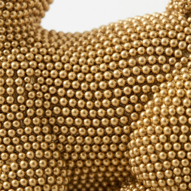 Macro shot beaded surface gilded cat sculpture