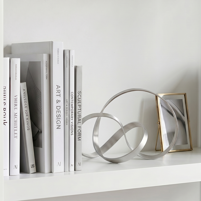 Metal loop sculpture displayed on wall mounted shelf