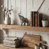 Resin elephant figurine on rustic wood wall shelf