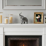 Textured elephant ornament on white fireplace mantel