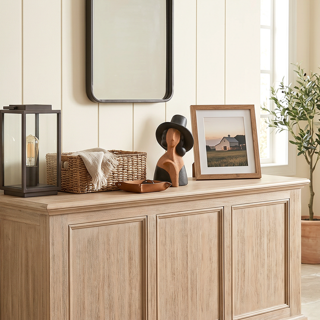 Two tone clay bust on light wood entry cabinet