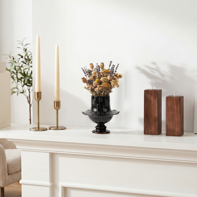 Vintage black vase on white stone fireplace shelf