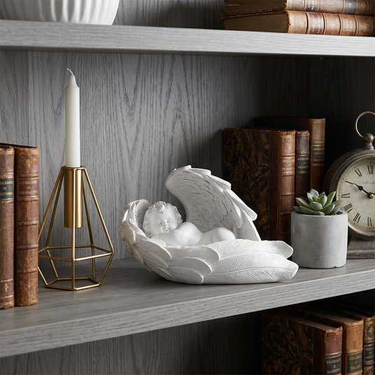 Winged angel decor on gray storage shelf