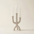 beige textured three prong candle holder with candles