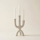 beige textured three prong candle holder with candles