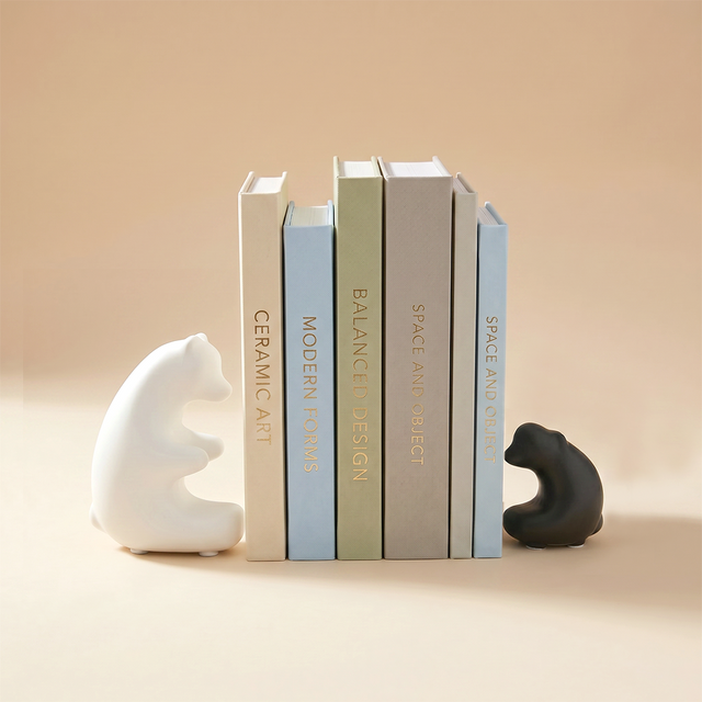 black and white bear bookends holding books
