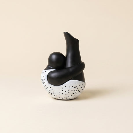 black ceramic figurine sitting with dotted base