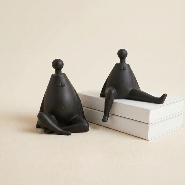black figurines beside white books