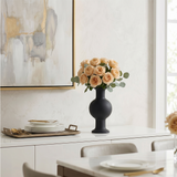 black vase with flowers on table