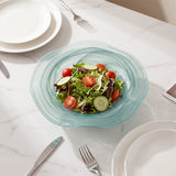blue glass salad bowl with salad on table