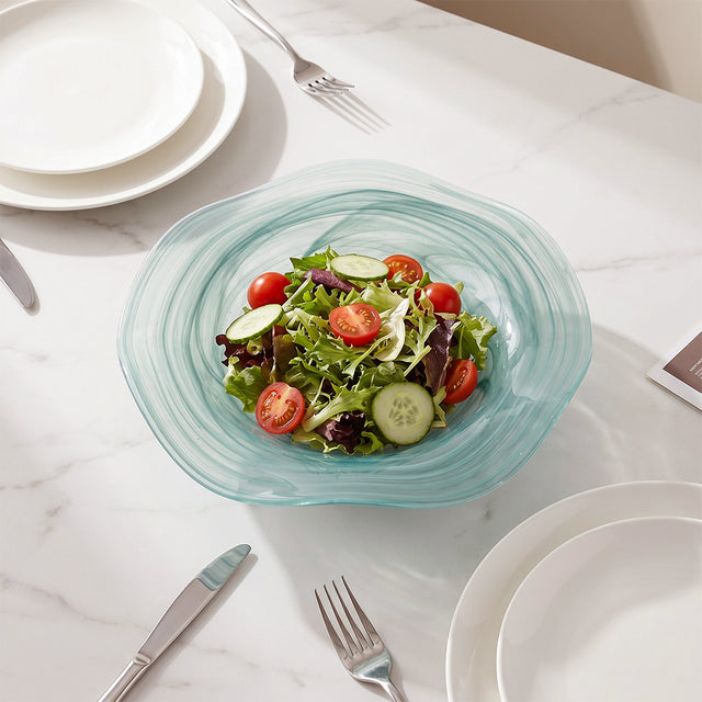 blue glass salad bowl with salad on table