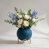 blue spherical vase with white roses on white