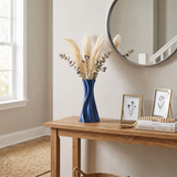 blue twisted vase with pampas on wooden entryway table