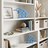blue wooden dolphins on white shelf with books