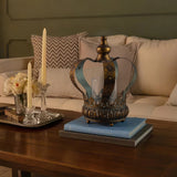bronze metal crown hurricane candle holder on books