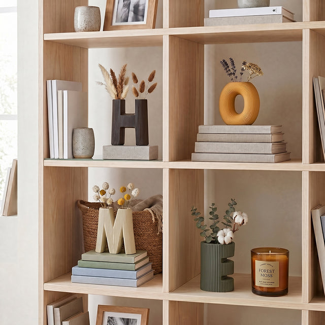 ceramic home letter vases on bookshelf with flowers