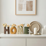 ceramic home letter vases with roses on white cabinet