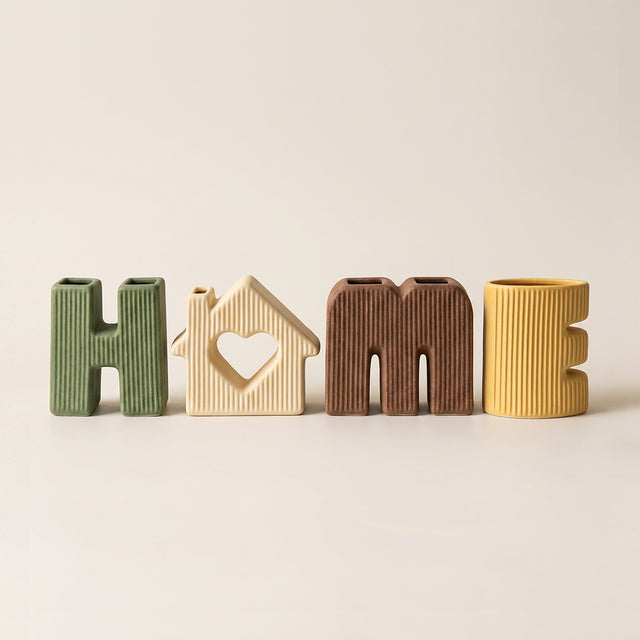 ceramic letter vases lineup on cream background