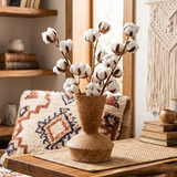 ceramic vase with cotton branches on table